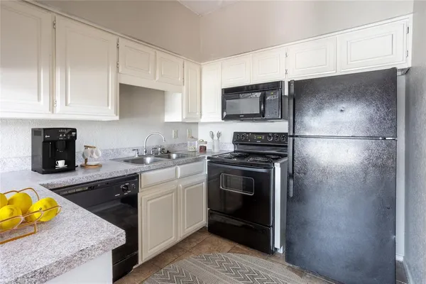 a kitchen with a sink appliances and cabinets