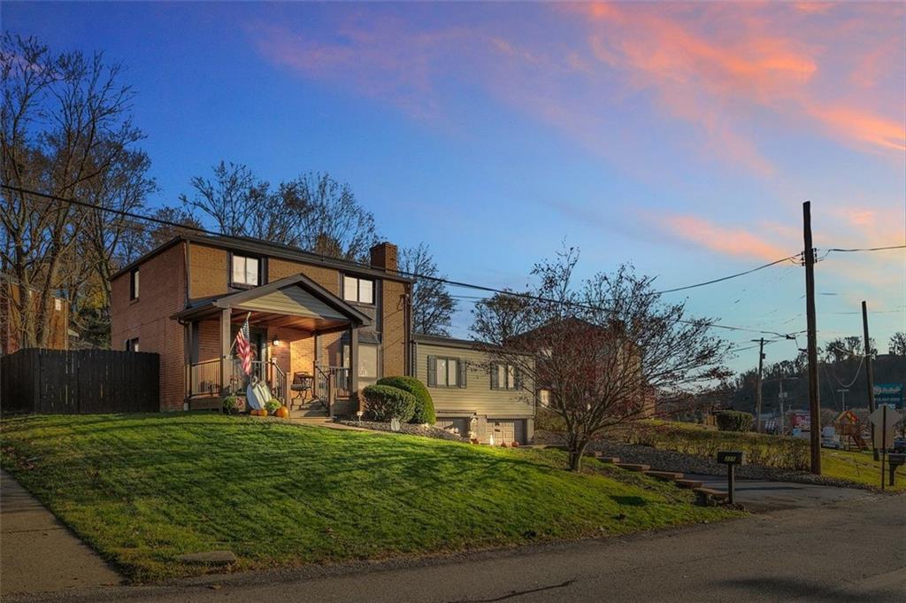 a view of a big house with a big yard and large trees