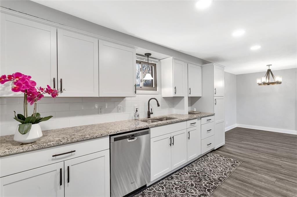 225 Houston Road Pittsburgh, PA 15237 - Photo 15 of 25 a kitchen with granite countertop a sink flowers stove and cabinets