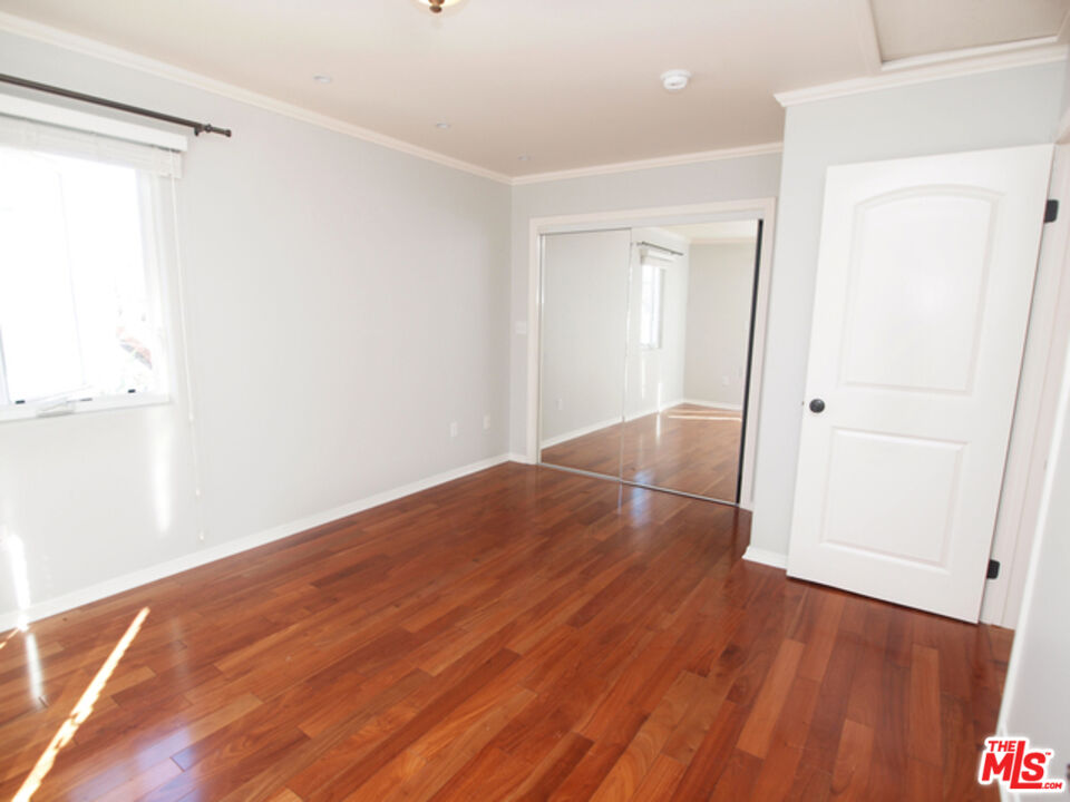 1644 Hi Point Street Los Angeles, CA 90035 - Photo 8 of 11 an empty room with wooden floor and closet