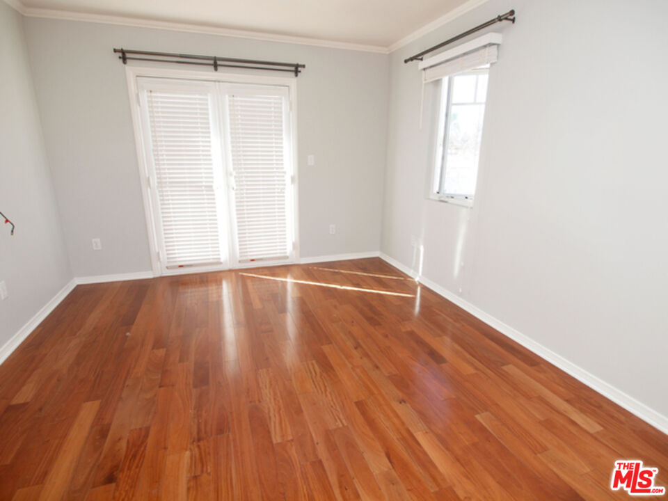 1644 Hi Point Street Los Angeles, CA 90035 - Photo 10 of 11 a view of an empty room with wooden floor and a window
