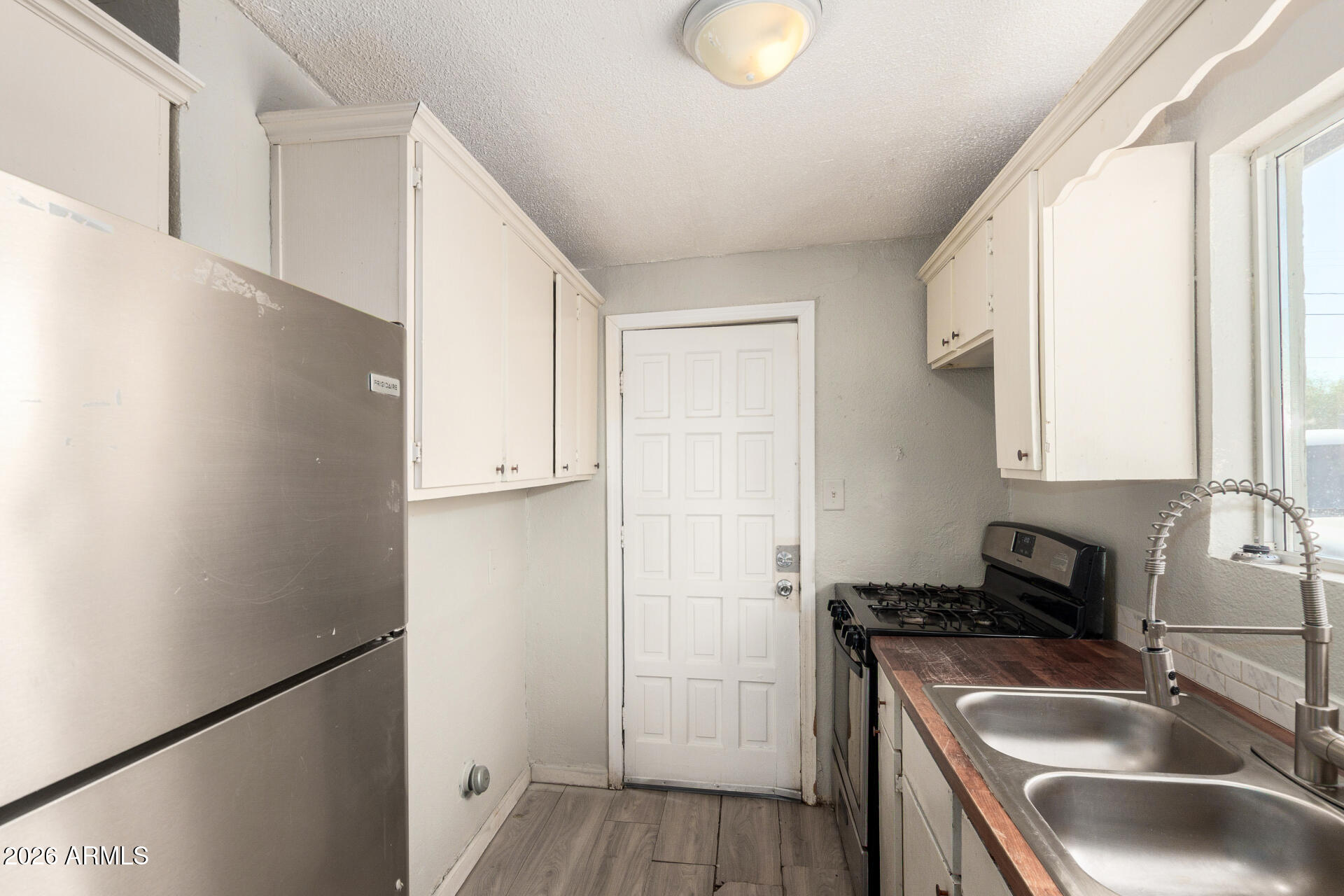 2135 West Hadley Street, Unit 1 Phoenix, AZ 85009 - Photo 11 of 18 a kitchen with a sink a refrigerator and a stove