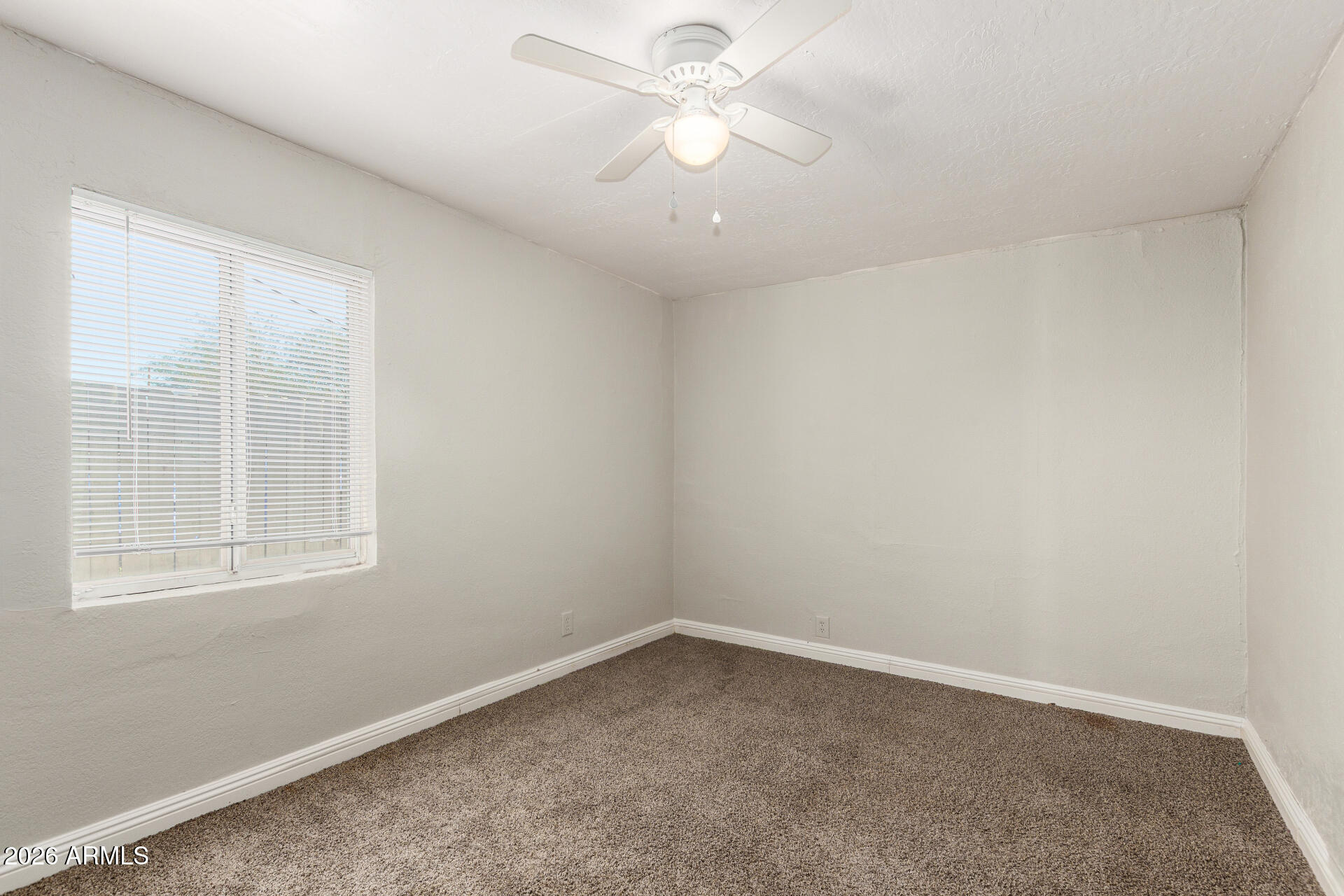 2135 West Hadley Street, Unit 1 Phoenix, AZ 85009 - Photo 13 of 18 an empty room with a window and a fan