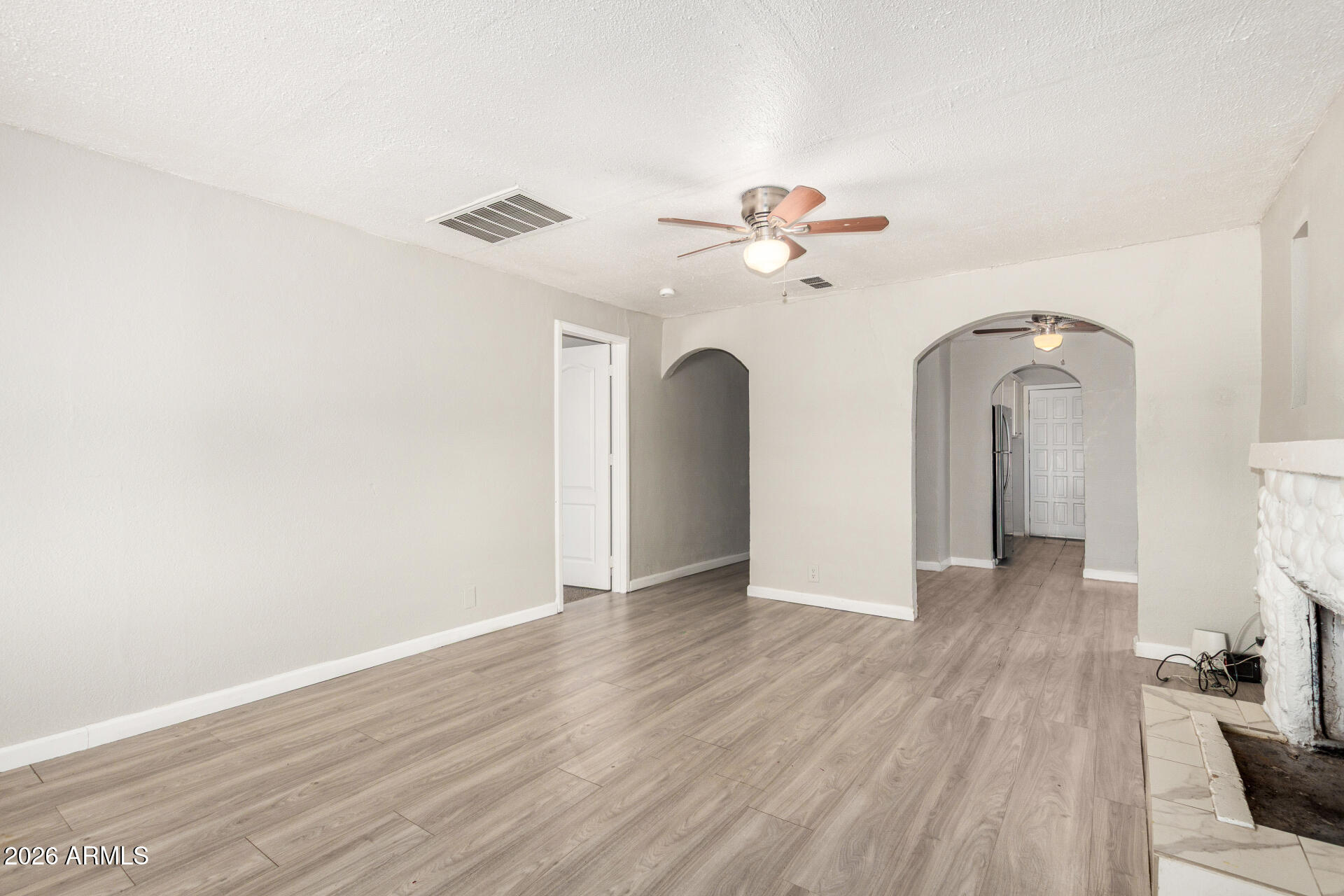 2135 West Hadley Street, Unit 1 Phoenix, AZ 85009 - Photo 4 of 18 an empty room with wooden floor and ceiling fan