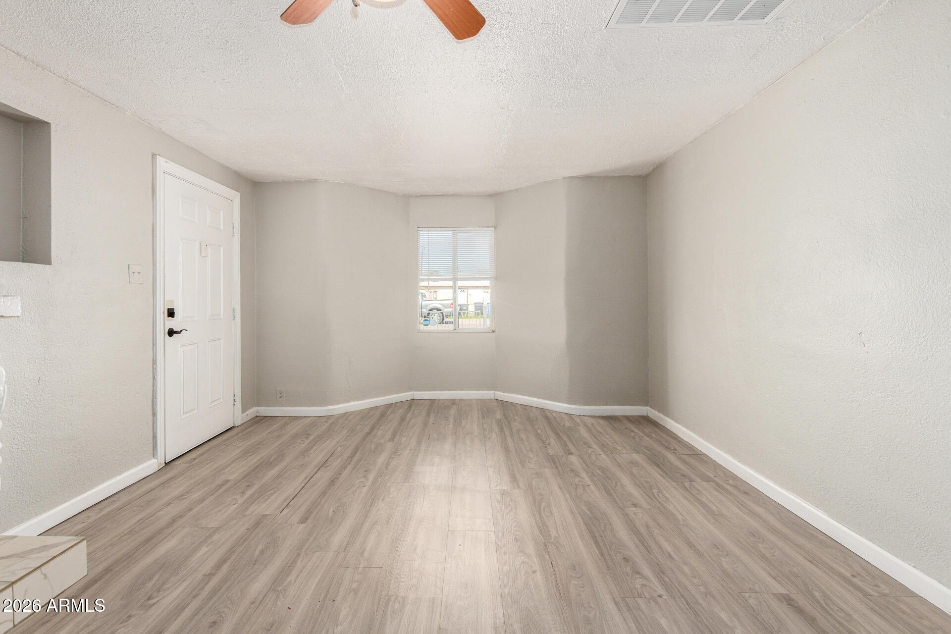 2135 West Hadley Street, Unit 1 Phoenix, AZ 85009 - Photo 6 of 18 an empty room with wooden floor and windows