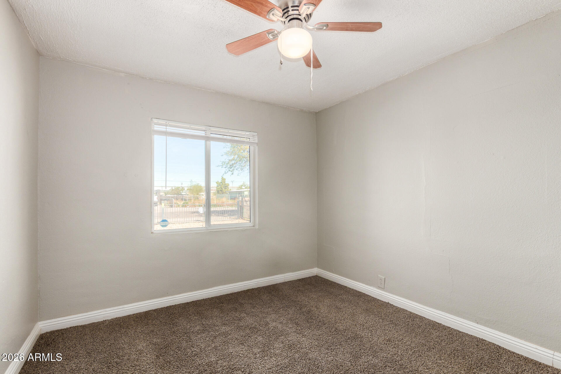 2135 West Hadley Street, Unit 1 Phoenix, AZ 85009 - Photo 7 of 18 an empty room with a window and a fan
