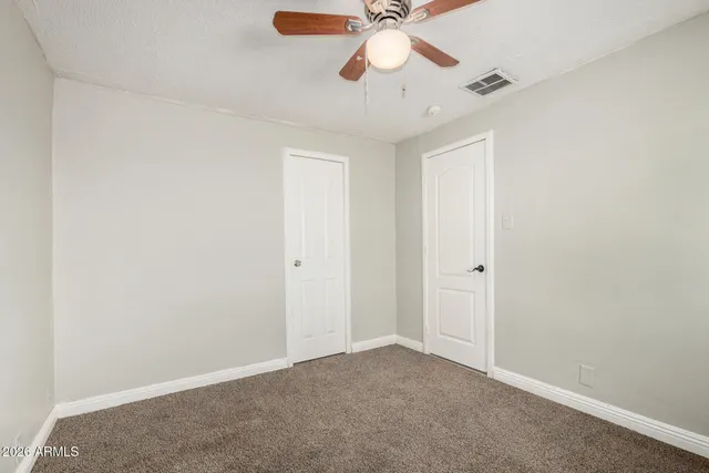 an empty room with a chandelier fan and a chandelier fan