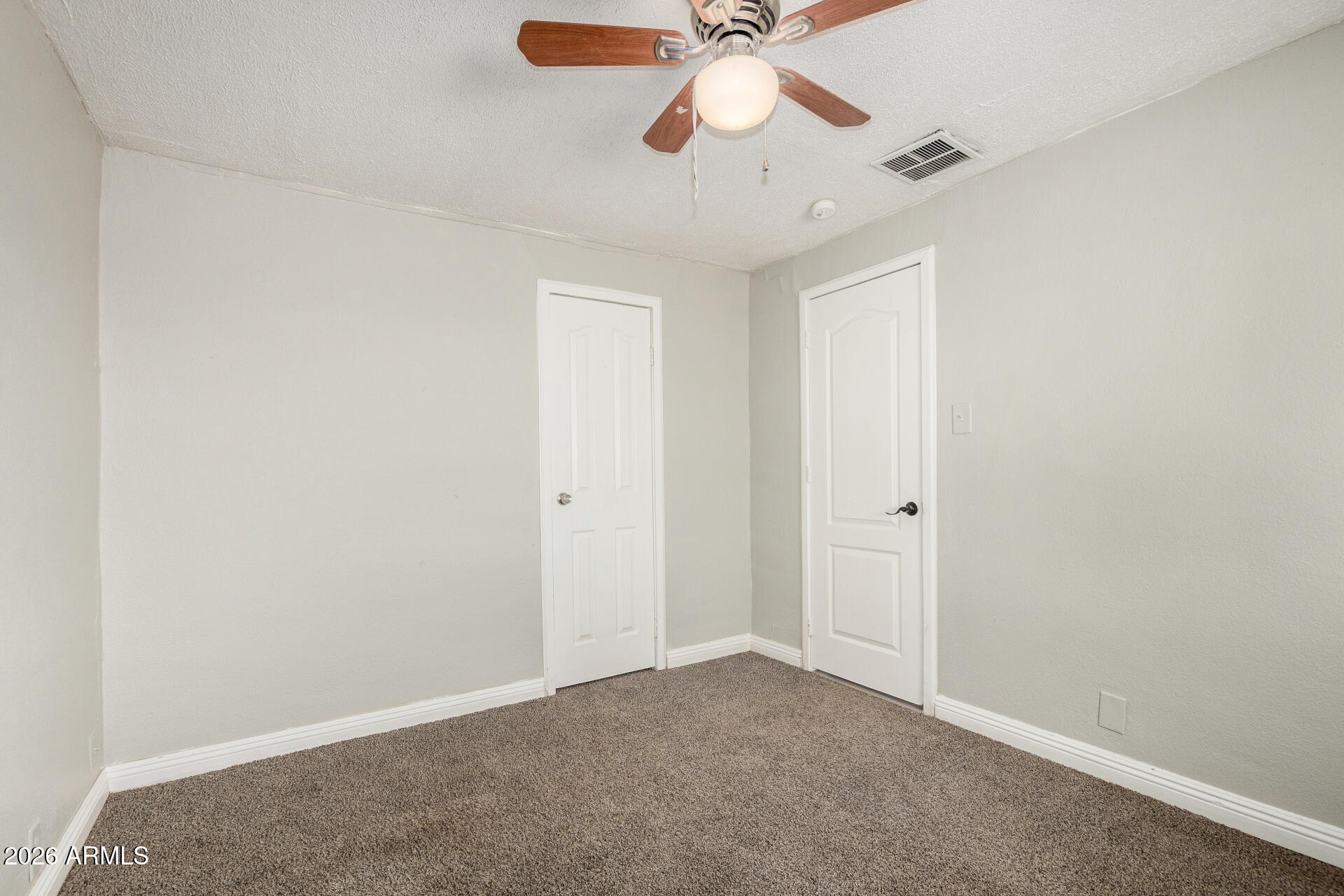 2135 West Hadley Street, Unit 1 Phoenix, AZ 85009 - Photo 8 of 18 an empty room with a chandelier fan and a chandelier fan