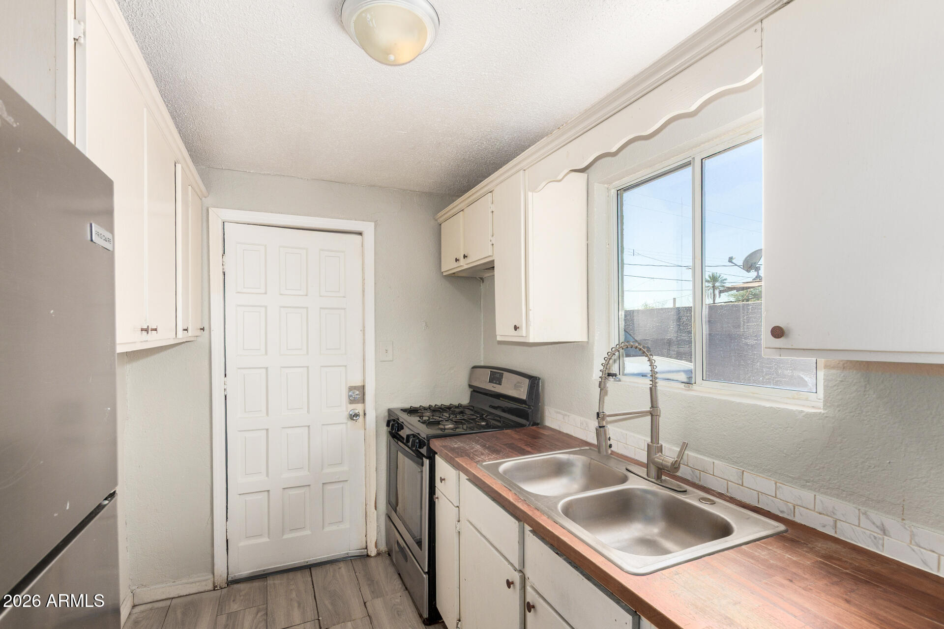 2135 West Hadley Street, Unit 1 Phoenix, AZ 85009 - Photo 10 of 18 a kitchen with sink refrigerator and window