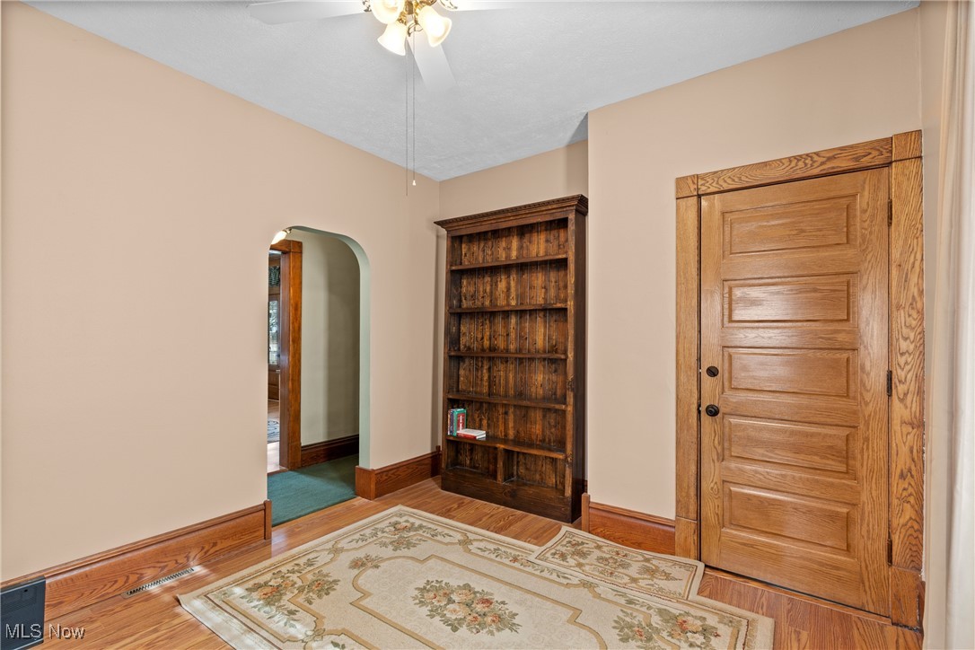 1011 Parriott Avenue Moundsville, WV 26041 - Photo 19 of 44 Bedroom featuring arched walkways, a ceiling fan, wood finished floors, and a closet
