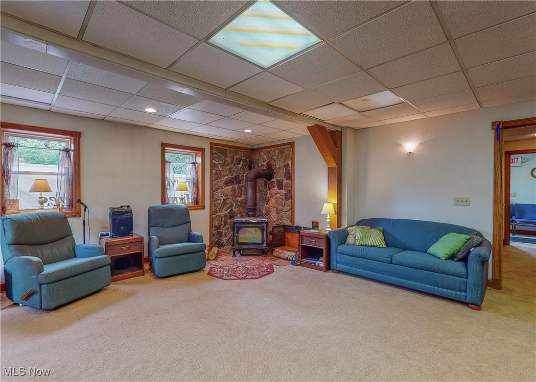 5696 Steubenville Road Southeast Amsterdam, OH 43903 - Photo 48 of 50 Living room featuring a paneled ceiling, carpet flooring, and a wood stove