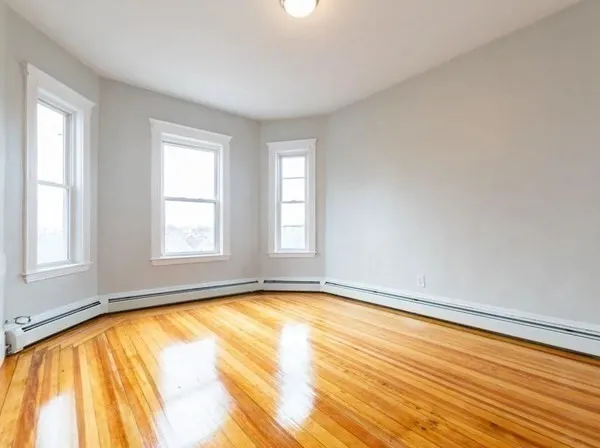 a view of a room with wooden floor and windows