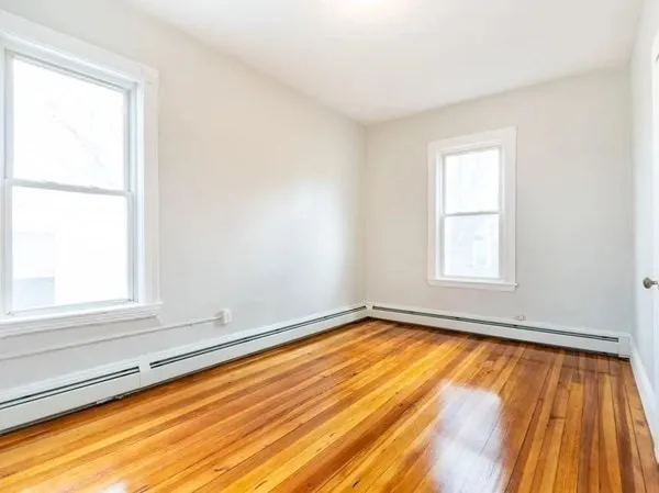 a view of an empty room with wooden floor