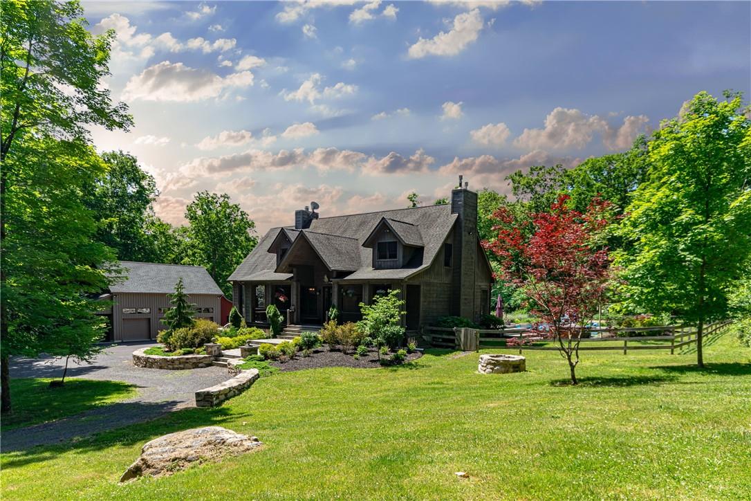 a front view of a house with garden and trees