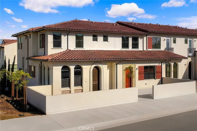 a view of a white house with large windows and a small yard