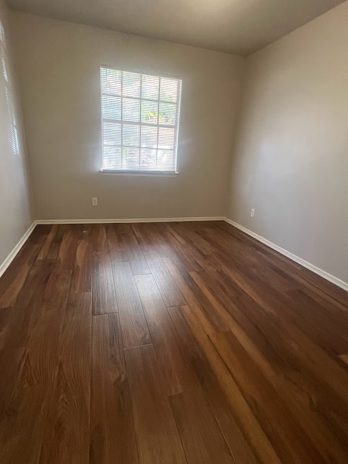 307 East 31st Street, Unit 102 Austin, TX 78705 - Photo 15 of 16 an empty room with wooden floor and windows