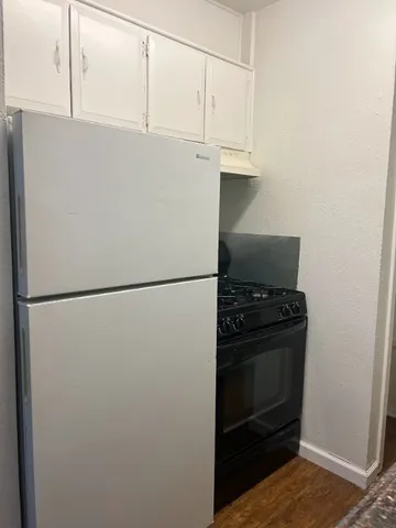 a white refrigerator freezer and a stove sitting inside of a kitchen