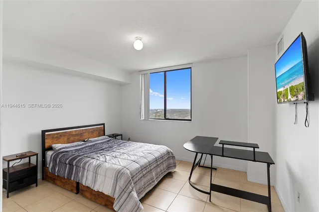 a bedroom with a bed and a flat screen tv