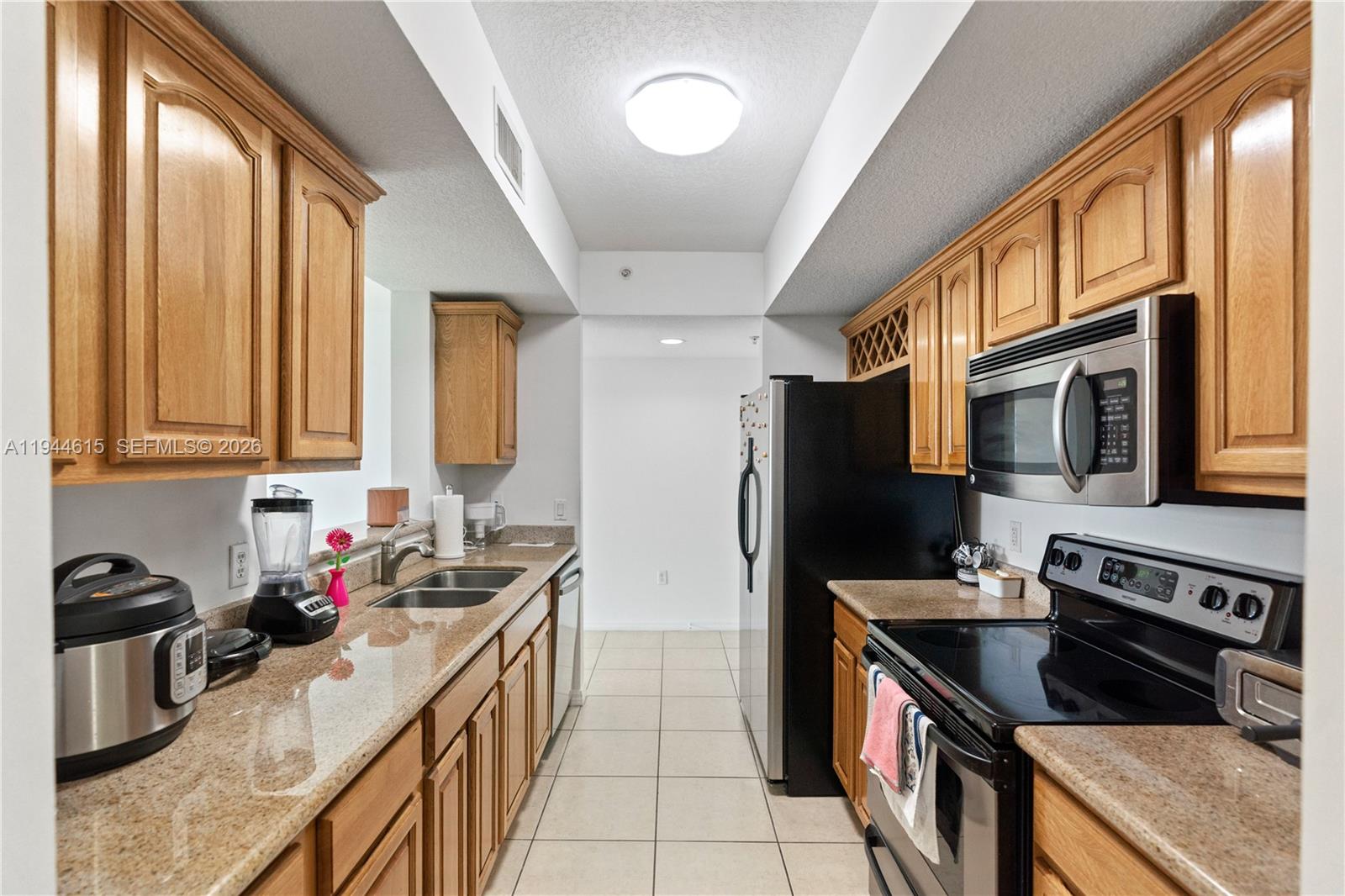 4242 Northwest 2nd Street, Unit 1609 Miami, FL 33126 - Photo 18 of 40 a kitchen with stainless steel appliances granite countertop a sink stove and refrigerator