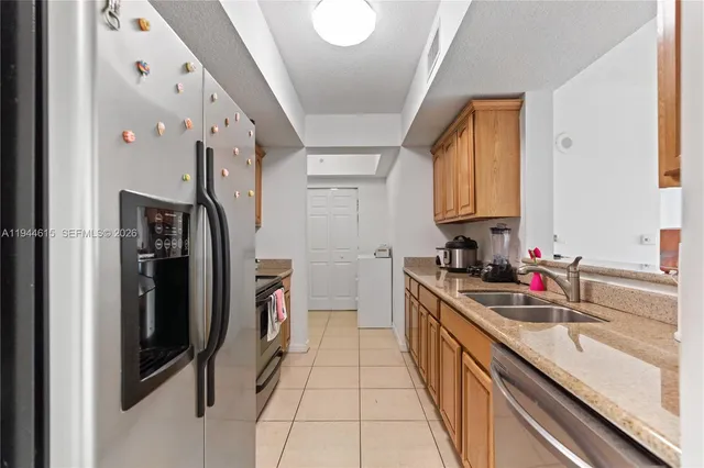 a kitchen with stainless steel appliances granite countertop a sink and a refrigerator