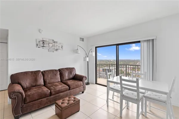 a living room with furniture and a floor to ceiling window