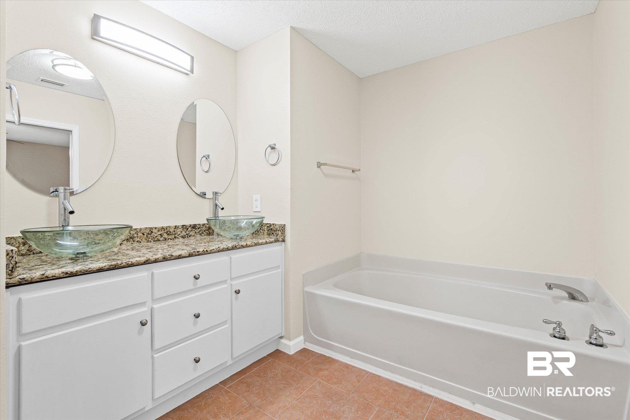 157 Bay View Drive Daphne, AL 36526 - Photo 9 of 22 Bathroom with light tile patterned flooring, double vanity, a bath, and a textured ceiling