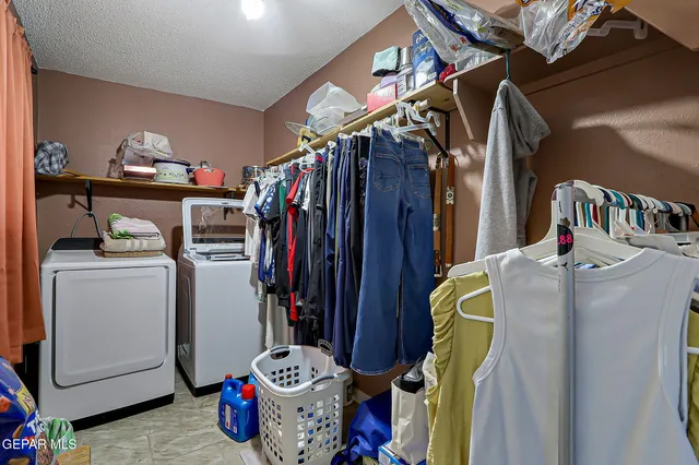 a view of walk in closet with clothes and shoes