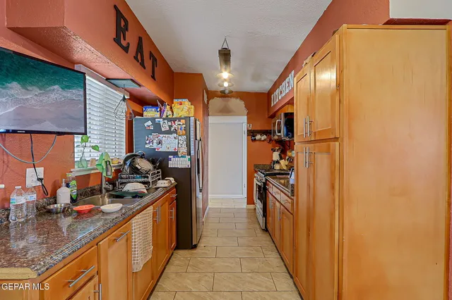 a kitchen with stainless steel appliances granite countertop a refrigerator and a sink
