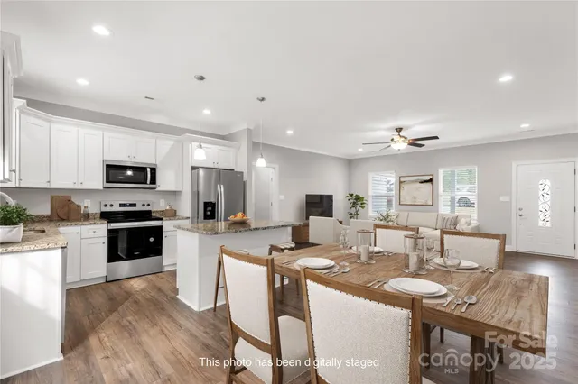 a large kitchen with kitchen island a sink table and chairs