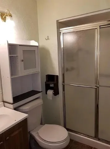 a bathroom with a toilet a sink and shower