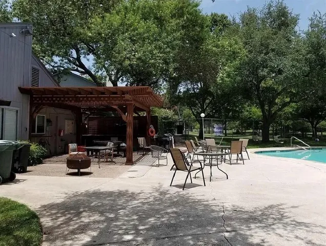 a view of backyard with table and chairs and a large tree
