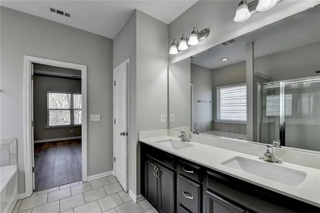 a bathroom with a double vanity sink a mirror and a shower
