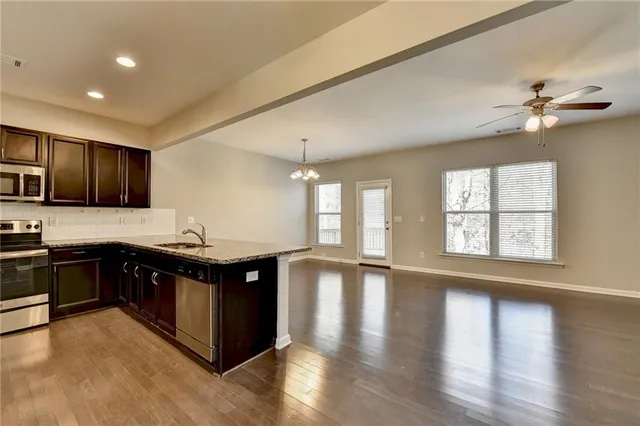 a kitchen with stainless steel appliances granite countertop a stove a sink and a refrigerator