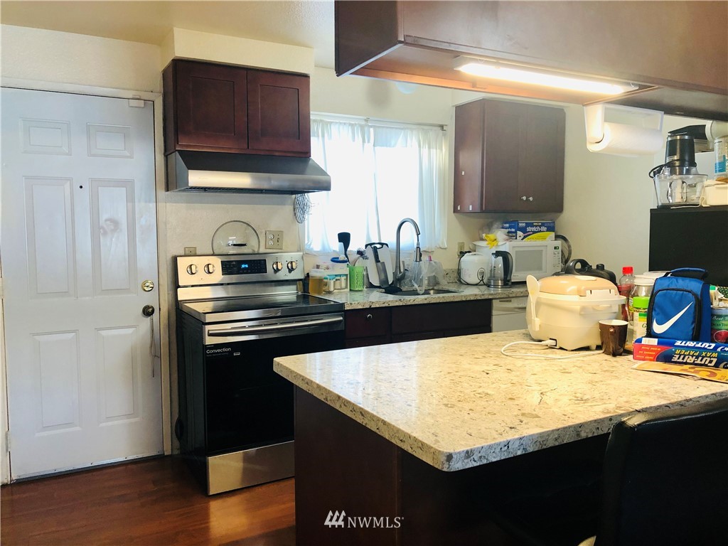 1421 North 3rd Street Renton, WA 98057 - Photo 13 of 17 a kitchen with granite countertop a sink cabinets and wooden floor
