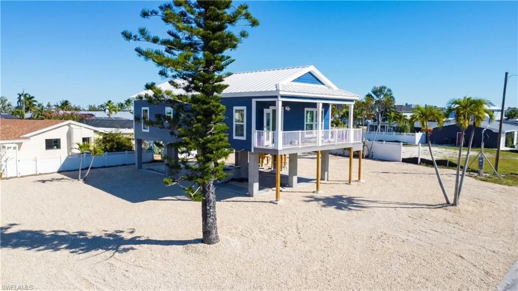 1 Fairview Boulevard Fort Myers Beach, FL 33931 - Photo 46 of 48 Beach home with a metal roof, a deck, a carport, and driveway - -VIRTUALLY EDITED
