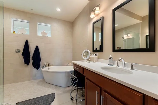 a bathroom with a bathtub sink and mirror