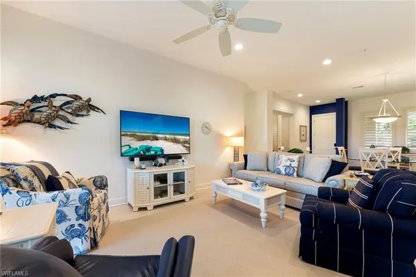 a living room with furniture a window and a flat screen tv