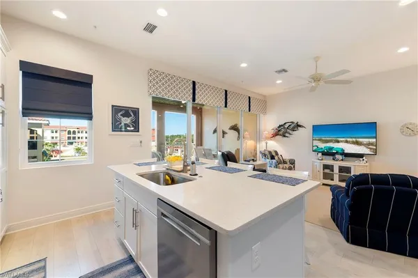 a kitchen with stainless steel appliances kitchen island granite countertop a sink a stove and a refrigerator