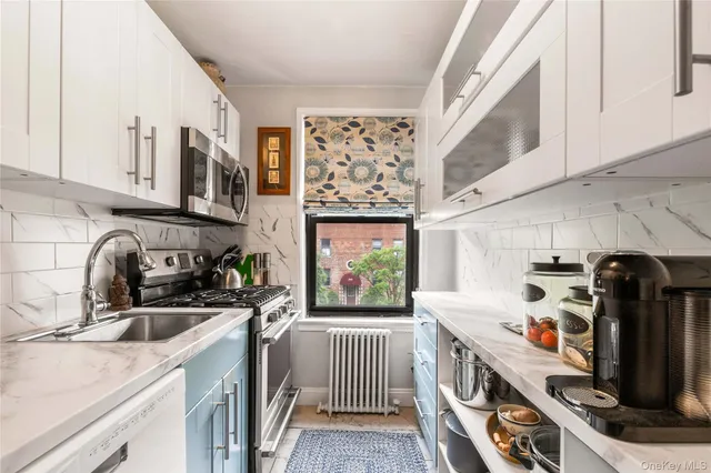 a kitchen with stainless steel appliances a sink a stove a microwave a sink and cabinets