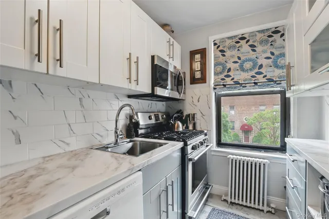 a kitchen with stainless steel appliances a sink a stove and cabinets