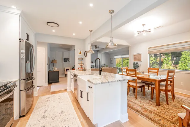 a kitchen with stainless steel appliances granite countertop a sink a stove and a wooden floors