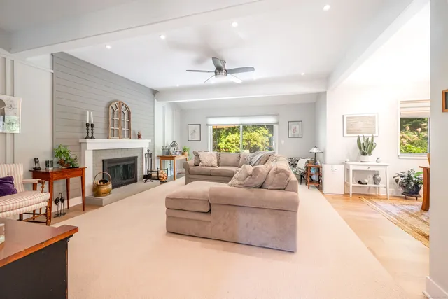 a living room with furniture fireplace and a window
