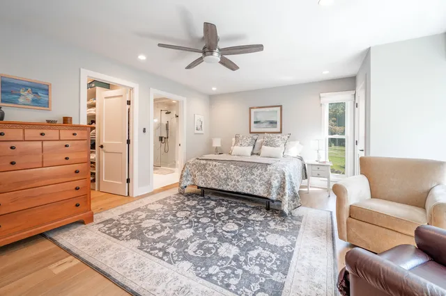 a bedroom with a bed couches and wooden floor