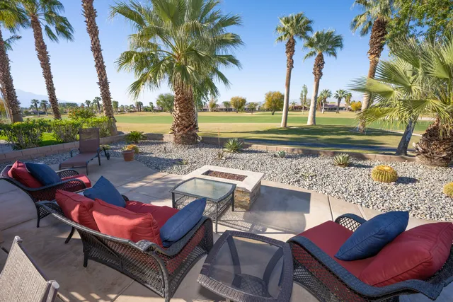 a view of a backyard with swimming pool and sitting area