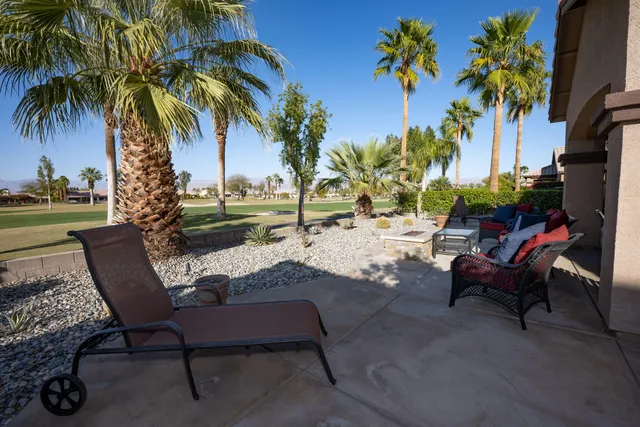 a view of a backyard with a patio table and chairs