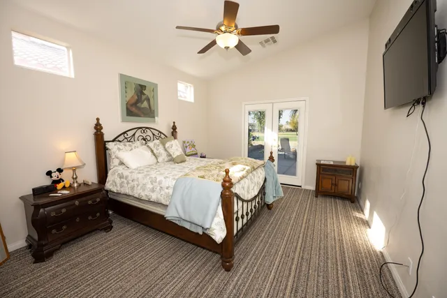 a bedroom with a bed and a flat tv screen on dresser