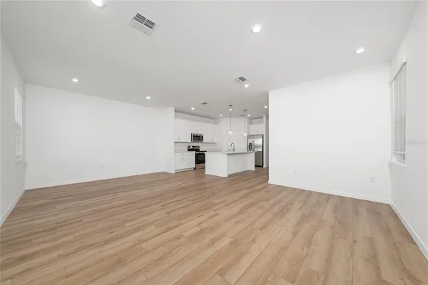 a view of empty room with wooden floor