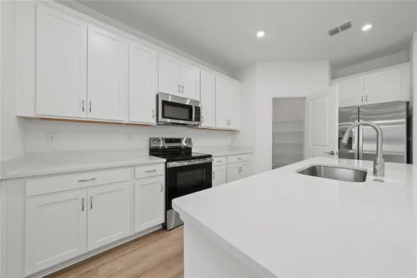 a kitchen with granite countertop white cabinets and stainless steel appliances