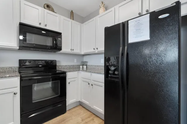 a kitchen with kitchen island granite countertop a dining table chairs and a refrigerator