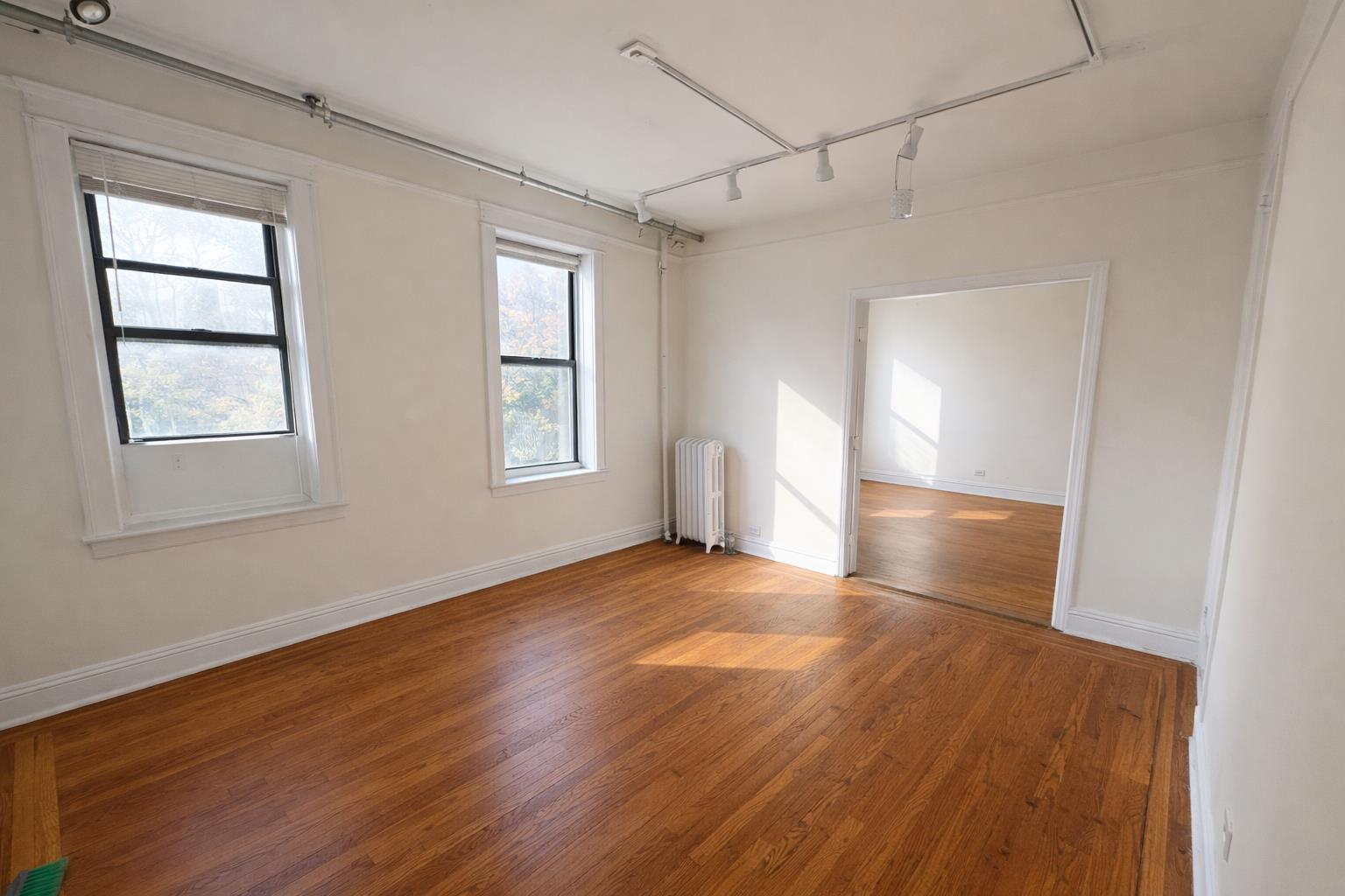 1825 Riverside Drive, Unit 5B Manhattan, NY 10034 - Photo 11 of 19 an empty room with wooden floor and windows
